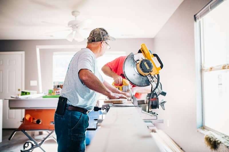 deux hommes en train de faire des travaux à l'intérieur d'une maison